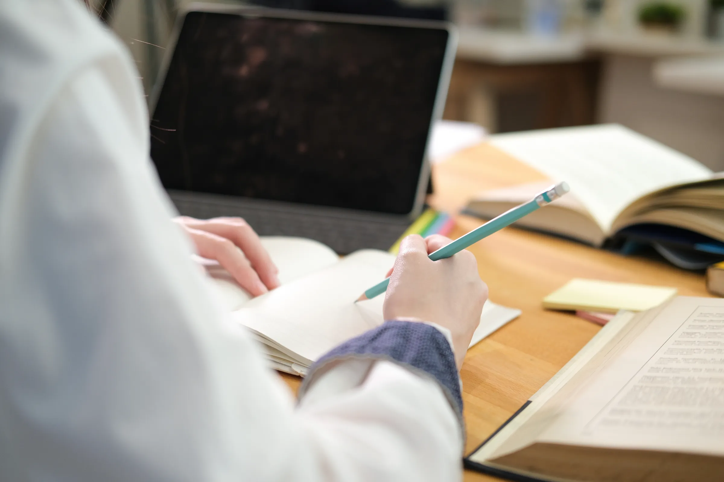Student taking notes at a desk